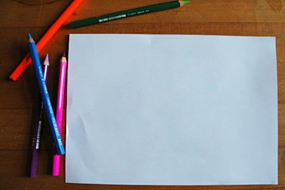 Symbolbild eines Blatt Papiers und vier Stiften für das Spiel "Galgenraten", bei dem ein gesuchter Begriff gefunden werden muss.
