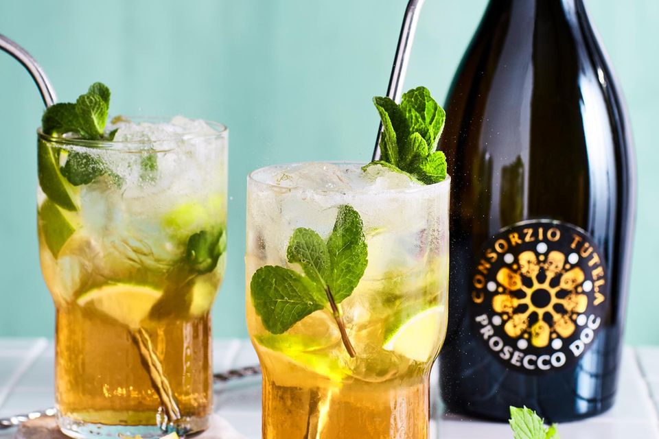 Cocktails mit Minze neben einer Prossecco-Flasche