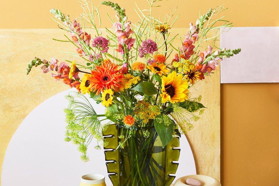 Bunter Blumenstrauß in einer grünen Glasvase
