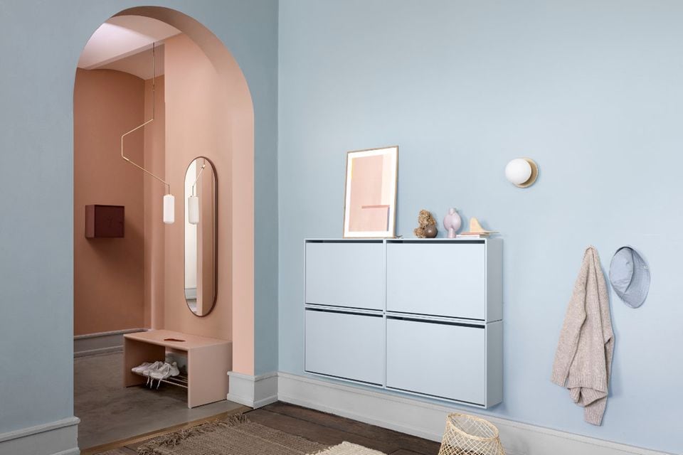 Moderner Flur mit pastellblauer Wandfarbe, Schuhschrank, runder Wandlampe, Dekoobjekten und roséfarbener Nische mit Spiegel