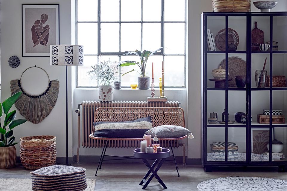 Fensterbank mit zwei Pflanzen, Kerzen, kleinen Objekten und Büchern in einem hellen, dekorativ eingerichteten Raum