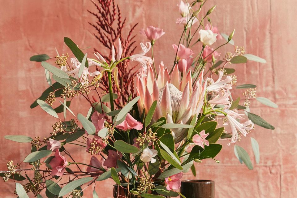 Grün-rosa Blumenstrauß auf einem Beistelltisch